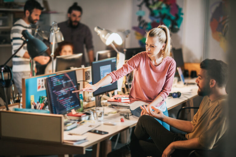 Team of young computer programmers cooperating in the office